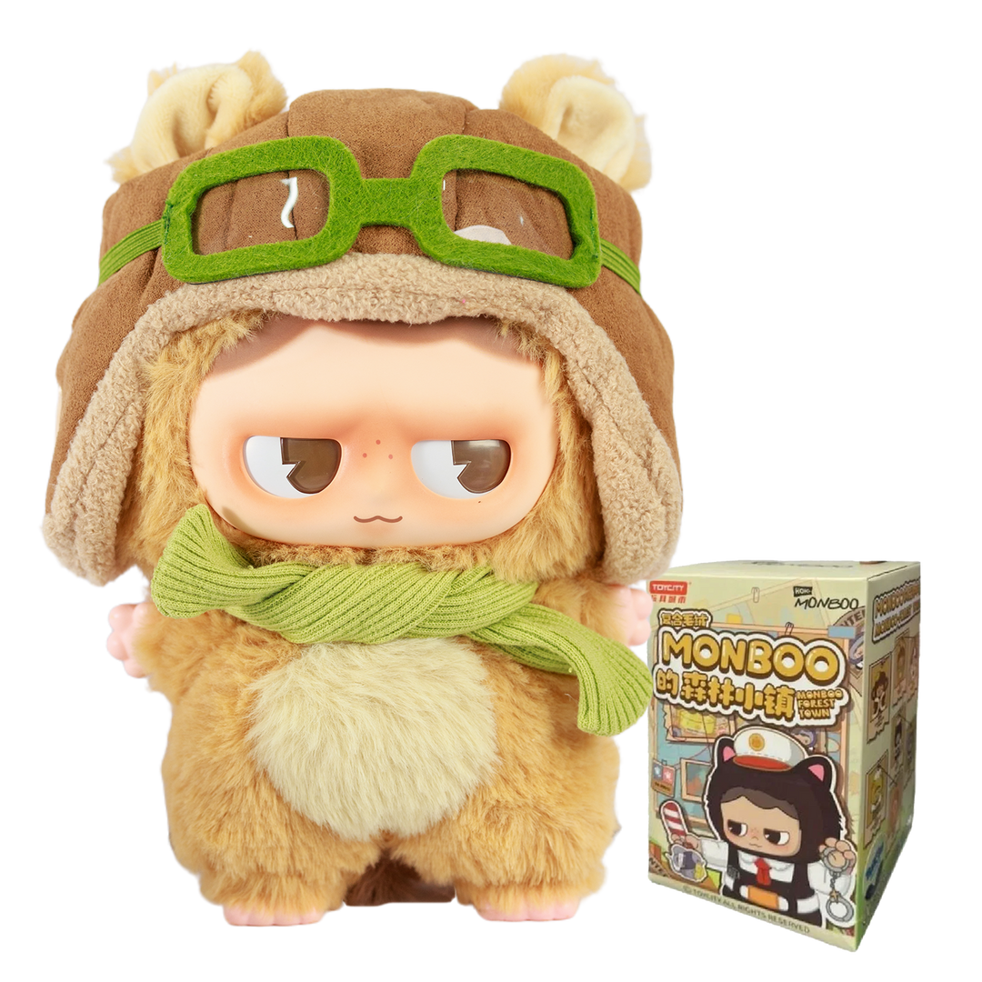 Plush toy resembling a monkey with a hat and goggles, next to its packaging box.